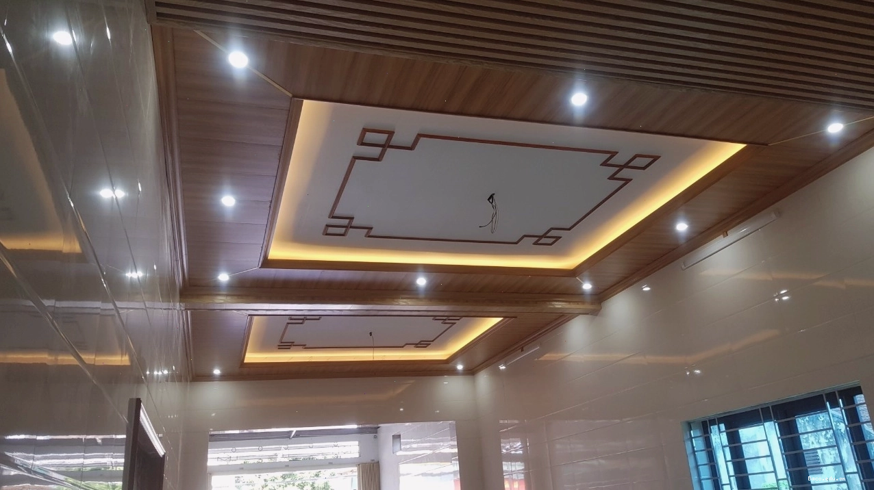Mẫu trần nhựa phòng khách giả gỗ với gam màu ấm áp, tạo cảm giác thân thiện