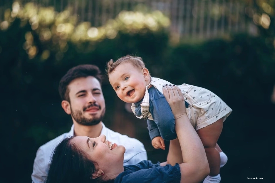 Một gia đình vui vẻ tận hưởng ngày nắng ngoài trời cùng em bé đang cười